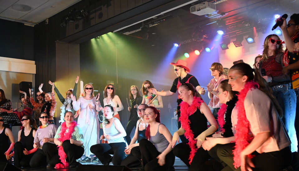 Musikere og dansere samlet på scenen.