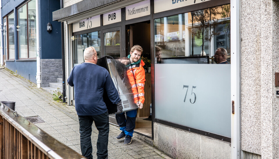 F.v.: Geir Charles Hansen og Mathias Dragseth bærer en kjøler ut i flyttebilen som står i Øvre Enggate og skal frakte alt ned til Kaibakken 1.
