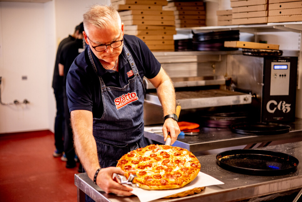 Nils Arne sjekker om pizzaen er akkurat slik den skal være, før alle får en smak.