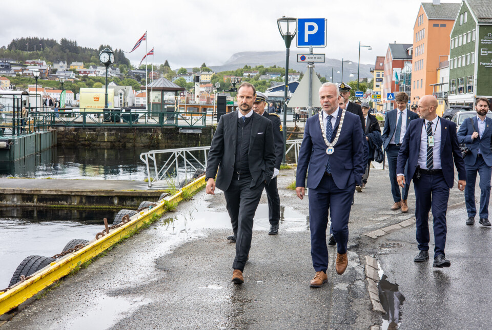 Kronprins Haakon Magnus og ordfører i Kristiansund Kjell Nergaard (Ap). Bak kommer politi, sikkerhetsvakter og personer fra hoffet.