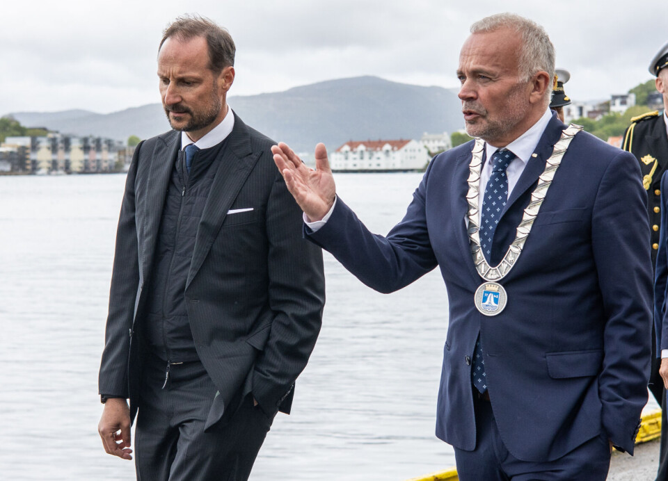 Kronprins Haakon Magnus og odfører i Kristiansund Kjell Nergaard (Ap). Ordføreren forteller om Campus Kristiansund. Bak kommer personer fra hoffet, politi og sikkerhetsvakter.