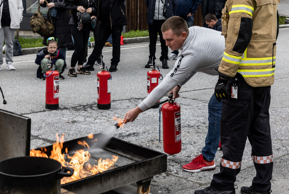BRANNSLUKKING: Nyankomne innbyggere i Averøy lærer å bruke brannslukningsapparat under en praktisk øvelse.