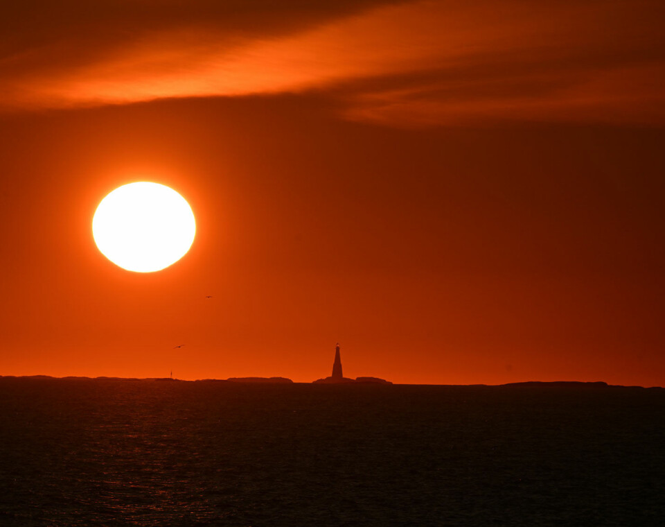 Solen, vår nærmeste stjerne i solsystemet i Orion-armen i galaksen Melkeveien, går ned i horisonten med Grip i forgrunnen, en sommernatt i juli i Kristiansund. FOTO: JOHN BERGE