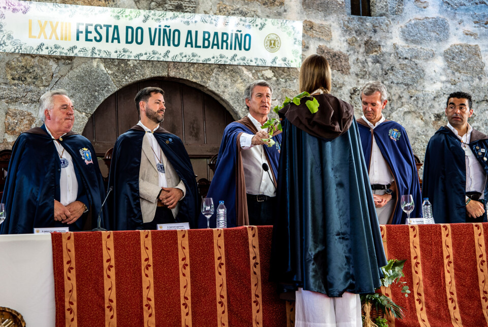 Skuespilleren María Mera Consuegra blir utnevnt til Dona do Albariño i den prestisjefylte Orden de los Cabaleiros e Donas do Albariño, under en lukket seremoni i borggården på det historiske slottet Pazo de Fefiñáns i Cambados. I bakgrunnen står Samuel Lago Ozón, ordfører i Cambados (PSOE), Alberto Núñez Feijóo, stormester i ordenen og leder for Partido Popular, og Alfonso Rueda, president i Galicia og også representant for Partido Popular – alle iført seremonikapper og medaljonger som tegn på sine roller i brorskapet.