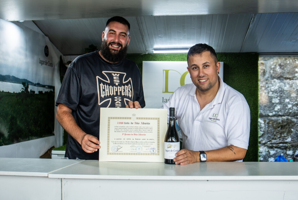 To ansatte fra Lagar de Costa viser stolt fram vinen og diplomet i utsalgsboden i Cambados – kort tid etter at bodegaen sikret tredjeplassen i årets Albariño-kåring. Dette var den eneste av de tre vinnerne som ble tilgjengelig for publikum samme dag.