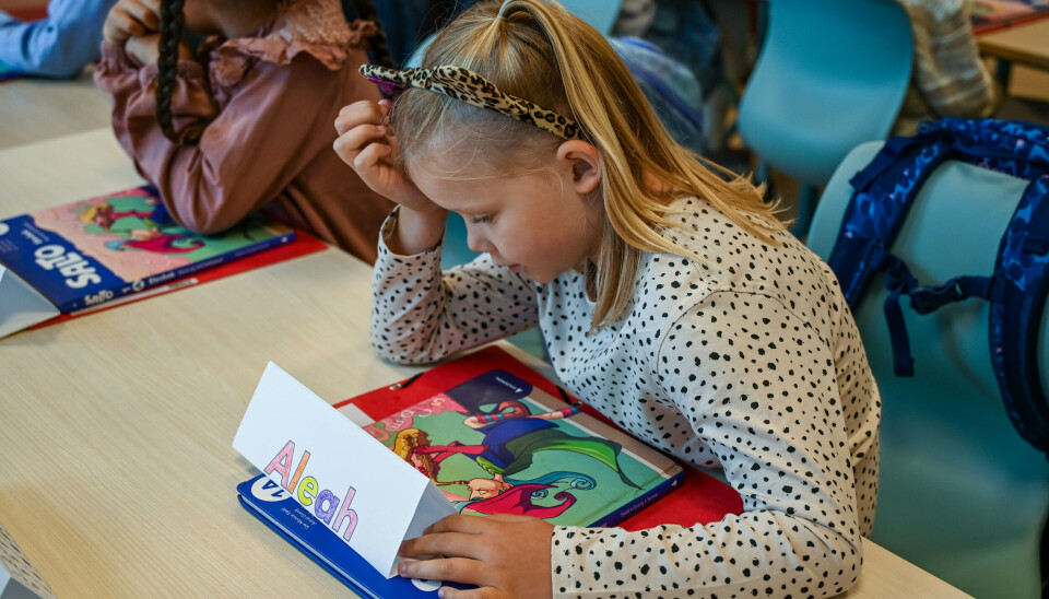 Aleah ser på permen og sin første skolebok.