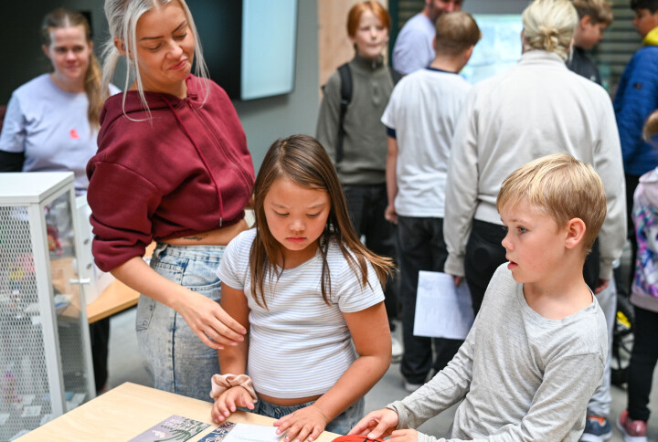Therese Nelvik, Charlotte Yodjaroen Olsen og Odin Nelvik Maridal ser på gamle skole aktiviteter fra lenge før vår tid.