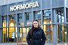 Person i mørk jakke står foran inngangen til kulturhuset Normoria.